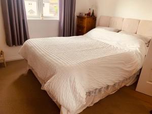 a white bed in a bedroom with a window at Home from home - Free Parking (near Edinburgh / Airport and Ingilston) in Edinburgh