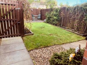 a small backyard with a fence and a yard withgrass at Home from home - Free Parking (near Edinburgh / Airport and Ingilston) in Edinburgh