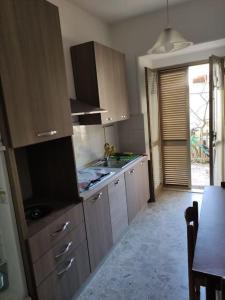 uma cozinha com armários de madeira e uma mesa com uma sala de jantar em Appartamento a 50mt dal mare em Amantea