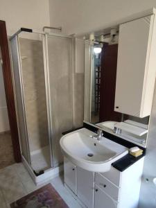 uma casa de banho com um lavatório branco e um chuveiro em Appartamento a 50mt dal mare em Amantea