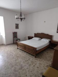 1 dormitorio con cama y lámpara de araña en Appartamento a 50mt dal mare, en Amantea