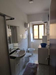 a bathroom with a sink and toilet and a window at Appartamento a 50mt dal mare in Amantea