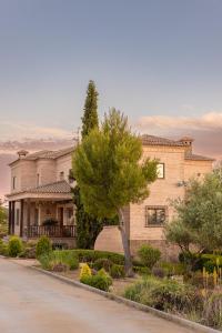 una gran casa de ladrillo con un árbol delante en CASA RURAL Cigarral del Pintor en Toledo