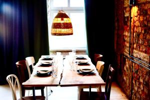 a wooden table with chairs and a chandelier at Loft with Lake View Pasym Koneser in Pasym
