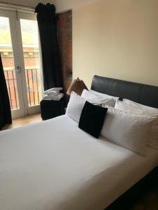 a large white bed with white pillows and a window at Contractor Bookers At Infinity Apartments in Liverpool