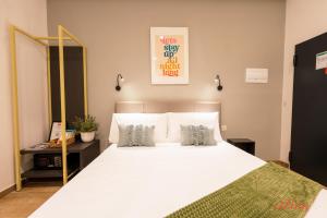 a bedroom with a large white bed with two pillows at Spinola Stays in St. Julianʼs