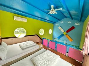 a bedroom with two beds in a room with a ceiling at Taroko Little Fish in Xincheng