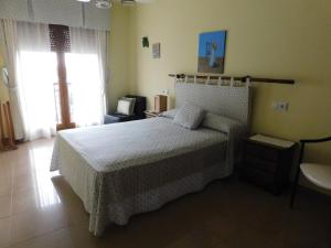1 dormitorio con cama blanca y lavamanos en Apartamentos As Caldelas, en O Grove