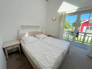een slaapkamer met een bed en een groot raam bij Strandpark Sierksdorf H056 in Sierksdorf