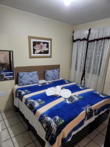 Un dormitorio con una gran cama azul con sábanas azules en Pousada Jasmine en João Pessoa