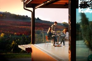 een man en een vrouw aan een tafel op een balkon bij Agriturismo Acetaia Sereni in Marano sul Panaro