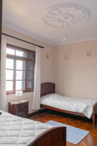 sypialnia z 2 łóżkami i oknem w obiekcie Sunset House w mieście Câmara de Lobos