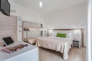 a hotel room with two beds and a television at Hotel Anastasi in Cervia