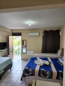 a hotel room with two beds and a television at Pousada Jasmine in João Pessoa