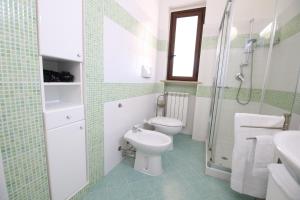 La salle de bains est pourvue de toilettes, d'une douche et d'un lavabo. dans l'établissement Costabella Apartment Tropea, à Tropea