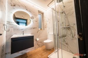 a bathroom with a shower and a sink and a toilet at Spinola Stays in St. Julianʼs