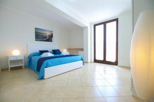 - une chambre blanche avec un lit bleu dans l'établissement Costabella Apartment Tropea, à Tropea