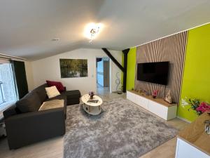 a living room with a couch and a tv at Ferienwohnung am Schutzgraben in Lübben