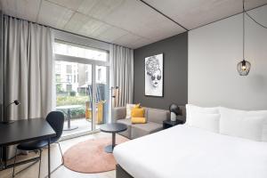 欧普菲康Radisson Hotel & Suites Zurich的一间带床的卧室和一间客厅