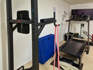 einen Fitnessraum mit einer Kraftgewichtsmaschine in einem Zimmer in der Unterkunft Qta do Eucalipto Villa in Faro