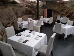 un comedor con mesas y sillas blancas en Posada Miranda, en Miranda del Castañar