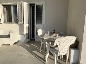 a white dining table and chairs in a room at Casa Flavia in Torre Chianca