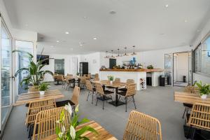 uma sala de jantar com mesas e cadeiras e um bar em En Plo Boutique Suites Oia Santorini em Oia