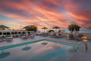 a pool with chairs and umbrellas on top of a hotel at En Plo Boutique Suites in Oia