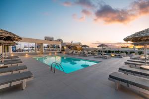 a swimming pool with chaise lounges and a resort at En Plo Boutique Suites Oia Santorini in Oia