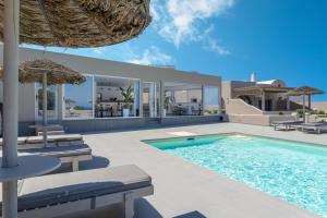 a villa with a swimming pool and a house at En Plo Boutique Suites Oia Santorini in Oia