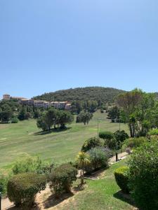 uma vista para um parque com um edifício ao fundo em Appartement Village Vacances Cap Esterel em Saint-Raphaël