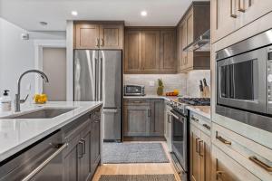 a kitchen with wooden cabinets and stainless steel appliances at BRAND NEW - Gorgeous Spring Creek Penthouse in Canmore