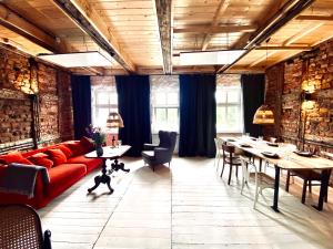 パシムにあるLoft with Lake View Pasym Koneserのリビングルーム(赤いソファ、テーブル、椅子付)
