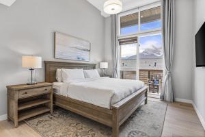 a bedroom with a large bed and a window at BRAND NEW - Gorgeous Spring Creek Penthouse in Canmore