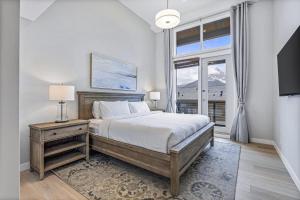 ein Schlafzimmer mit einem Bett und einem großen Fenster in der Unterkunft BRAND NEW - Gorgeous Spring Creek Penthouse in Canmore