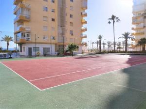 un campo da tennis di fronte a un edificio di Beachfront apartment ALG-Costa a Algarrobo-Costa