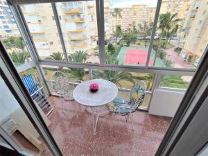 un tavolo e sedie su un balcone con campo da tennis. di Beachfront apartment ALG-Costa a Algarrobo-Costa