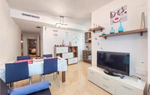 ein Wohnzimmer mit einem Esstisch und einem TV in der Unterkunft Beautiful Apartment In Benicarló in Benicarló