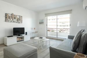 a living room with a couch and a tv at Marina Vilamoura Relax Apartment in Vilamoura