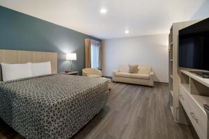 ハーミテイジにあるWoodSpring Suites Hermitage - Nashville Airportのベッドと薄型テレビがあるホテルの部屋