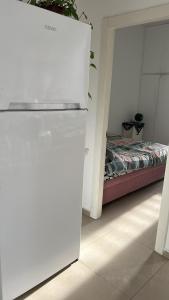 een kamer met een bed en een witte koelkast bij Apartment near Hilton in Tel Aviv