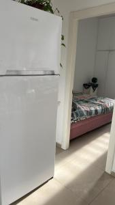 a room with a bed and a white refrigerator at Apartment near Hilton in Tel Aviv