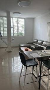 a living room with a couch and a table and chairs at Apartment near Hilton in Tel Aviv