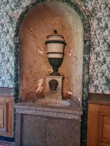 eine Vase auf einem Stand in einem Raum in der Unterkunft Château de Barral in Hauterives