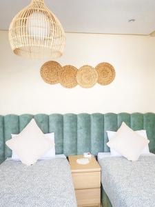 um quarto com 2 camas e uma cabeceira verde em Appartements California em Kenitra
