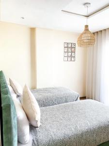 um quarto com 2 camas e almofadas em Appartements California em Kenitra