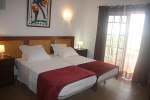 Un dormitorio con una cama grande y una ventana en Rustic Villa Guesthouse, en Santa Bárbara de Nexe