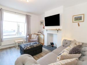 uma sala de estar com um sofá e uma televisão em Donnys Plaice em Great Yarmouth