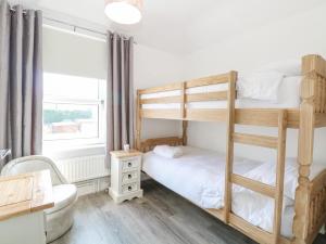 a bedroom with two bunk beds and a desk at Donnys Plaice in Great Yarmouth