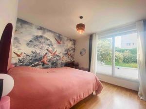 1 dormitorio con 1 cama con una pintura en la pared en Le Rosa Bonheur, en Nantes